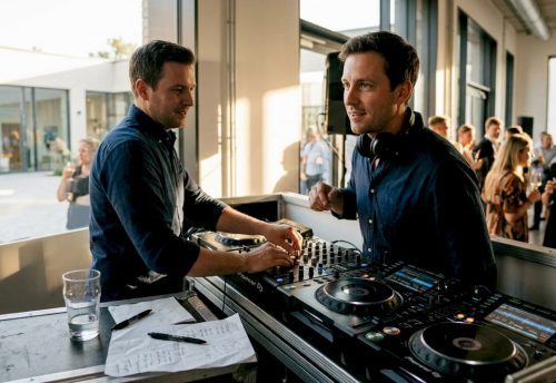 Ein DJ legt beim Event live Musik am Mischpult auf.