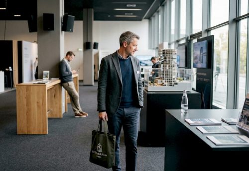 Ein Messebesucher schlendert in aller Ruhe am Ausstellungsstand vorbei.
