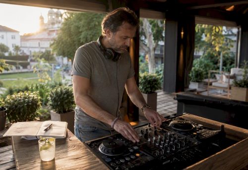Ein DJ legt in der Eventhalle in Salzburg auf und sorgt mit seinem Mixerpult für die richtige Stimmung.