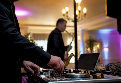 DJ und Saxophonist bauen gemeinsam ihr Equipment für die bevorstehende Veranstaltung auf.