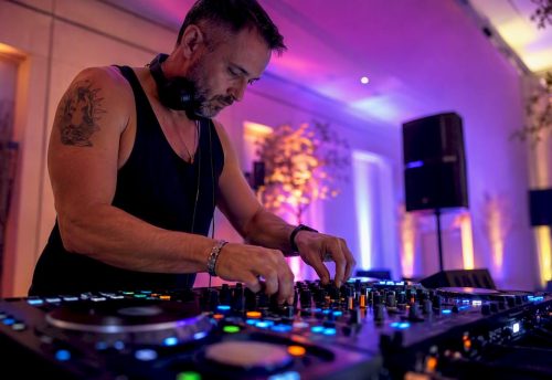 DJ legt Musik am Mischpult auf und stellt sein Set individuell zusammen.